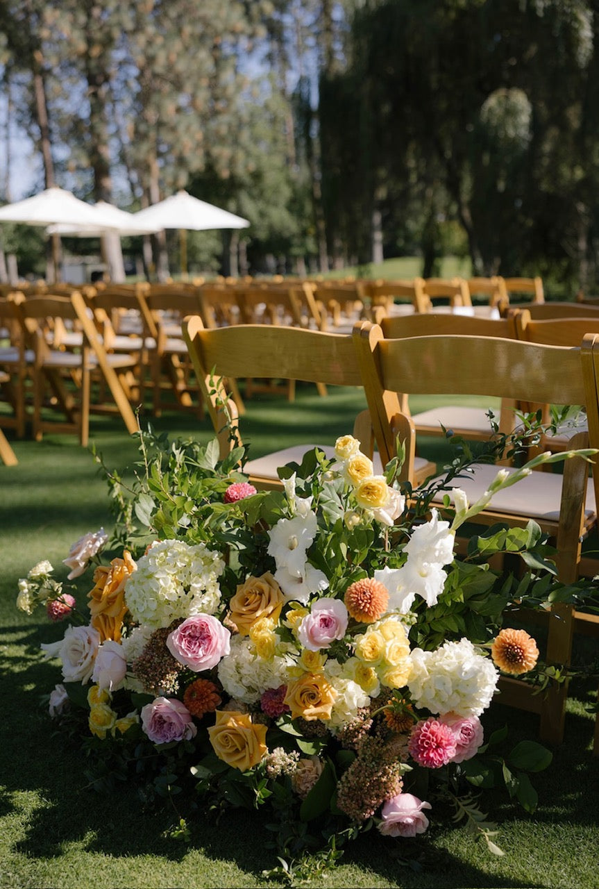 Wedding aisle entrance floral arrangement in beautiful shades of pink, yellow, gold and white. 