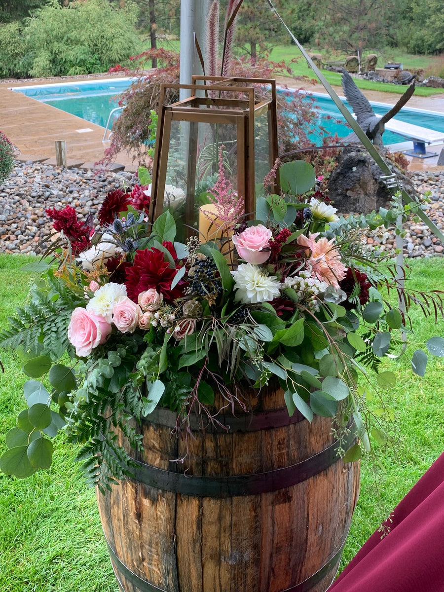 Rustic wedding wildflower floral arrangement inspiration in wooden barrel. Arrangement was create by Daisies in May