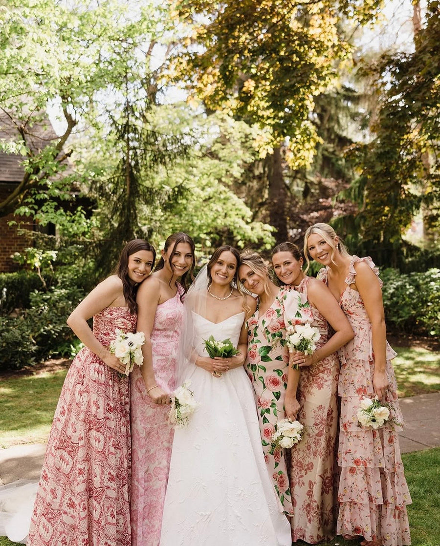 Bride with bridesmaids in floral dresses and white bouquets from Daisies in May