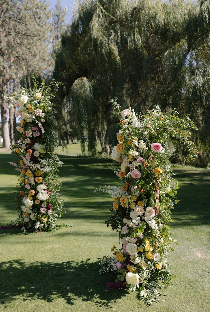 Broken arch adorned with flowers at Manito Country Club wedding by Daisies in May, Spokane florist