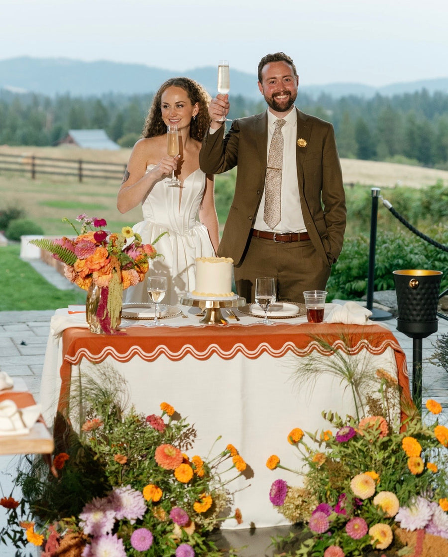 Couple toasting their wedding at a scenic Spokane, WA wedding with seasonal floral arrangements.