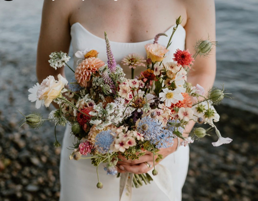 Delicate wedding bouquet with shades of baby blue, white, cream, peach and pink florals in Spokane, Washington