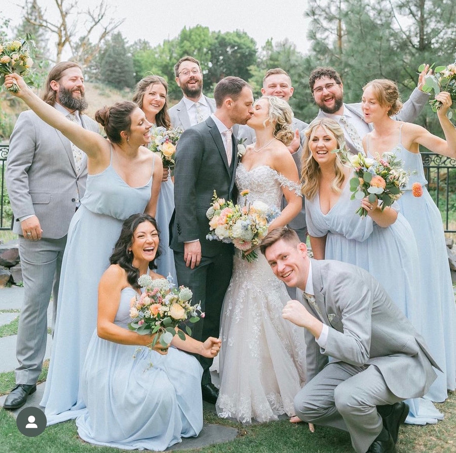 Light blue wedding with pastel peach, pink, blue, white and green floral bouquets from Daisies in May wedding florist in Spokane, WA