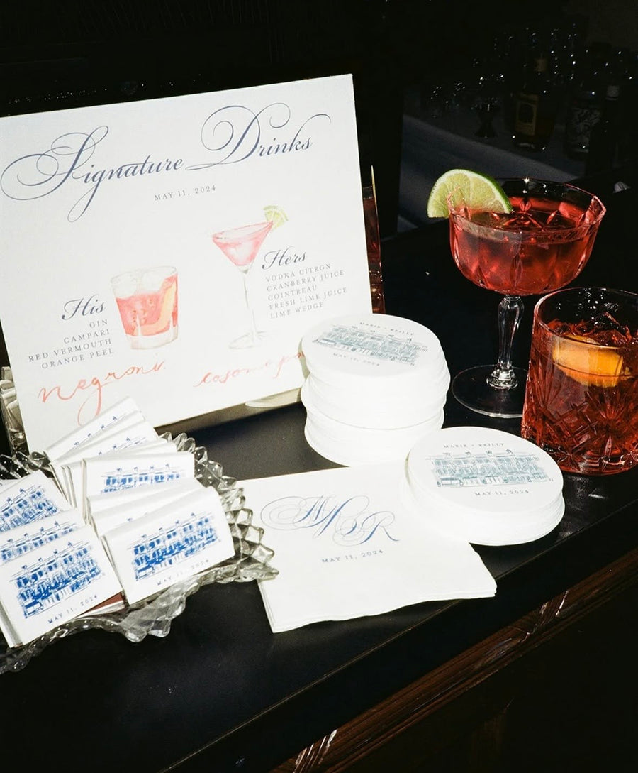 Signature drinks menu with cocktail glasses and coasters on a dark surface