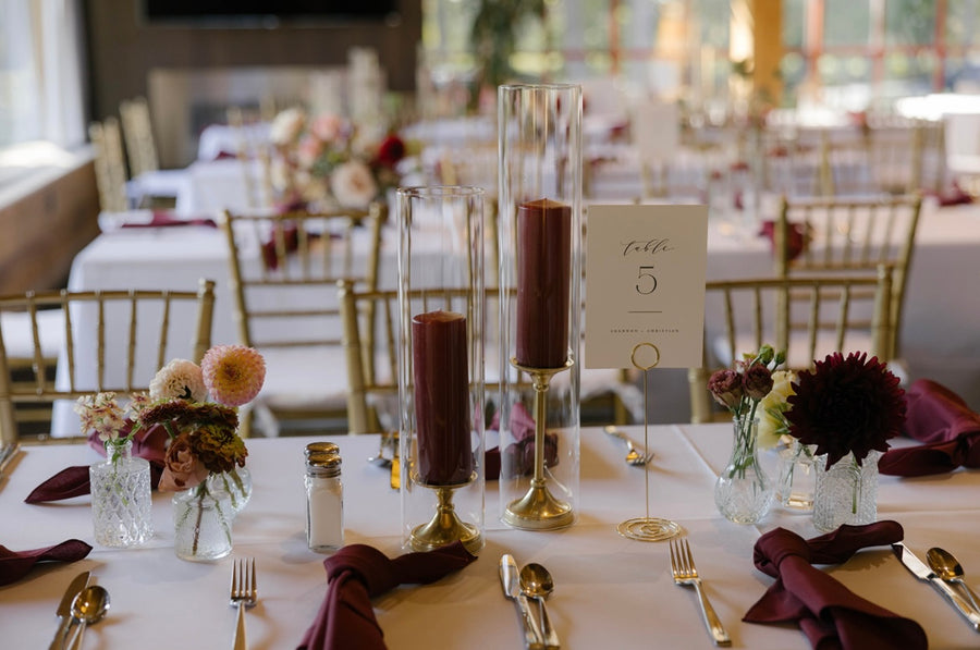 Burgundy pillar candles and flowers adorn a wedding at Manito Country Club in Spokane, WA