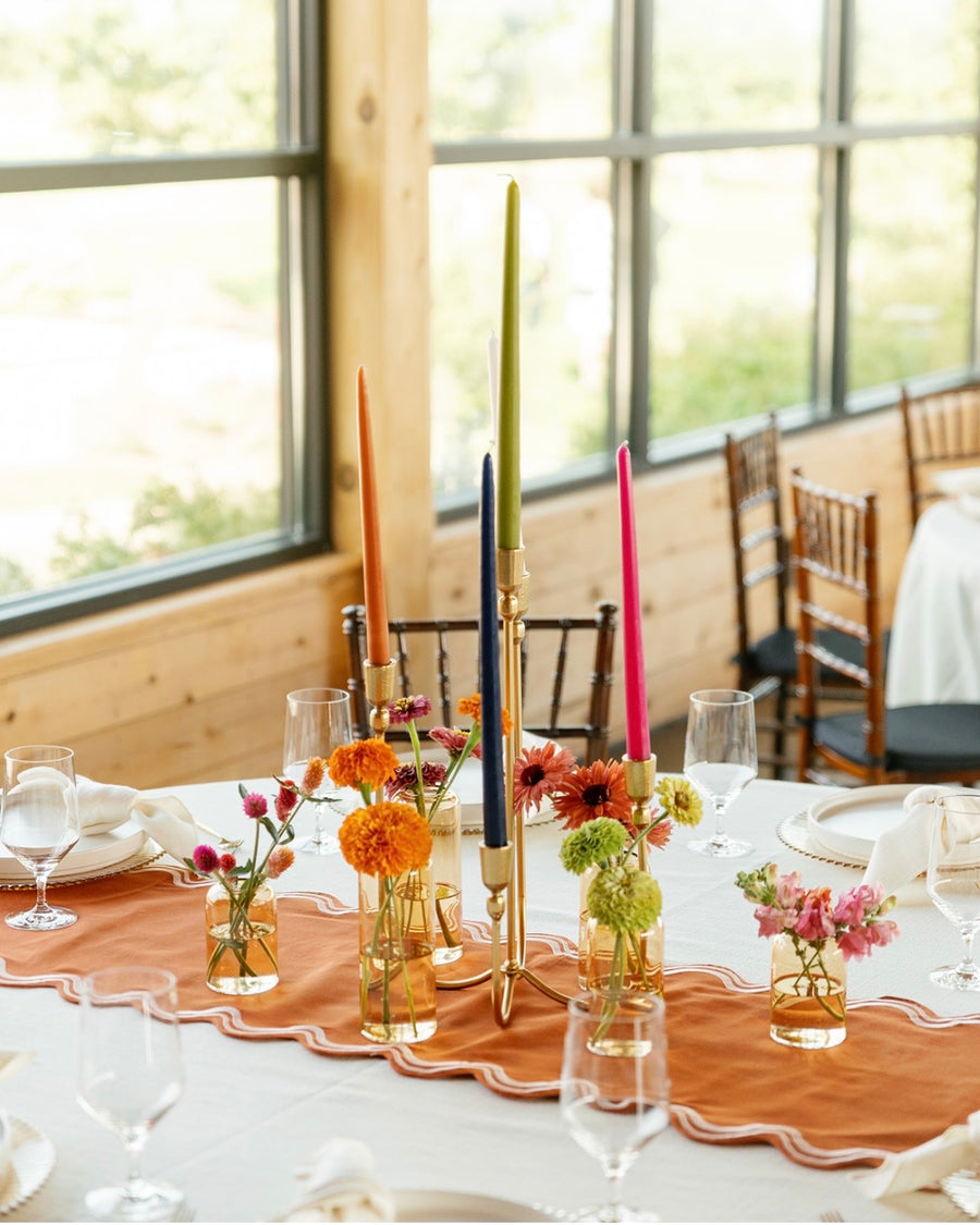 Decorated table with floral centerpieces and colorful candles at a fall themed wedding reception in Spokane, WA