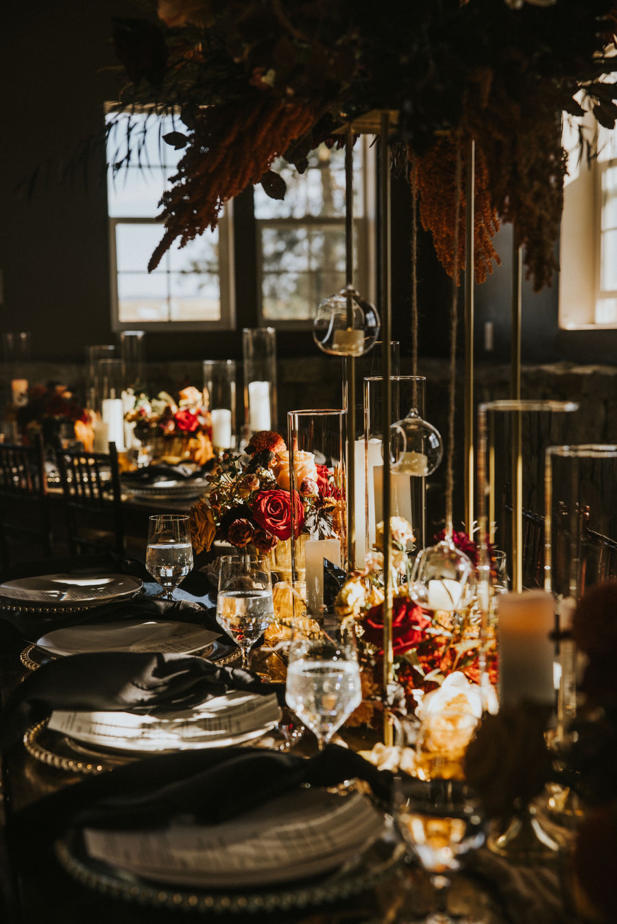 Elegant table setting with candles, flowers, and glassware with stunning fall floral arrangements by Daisies in May.